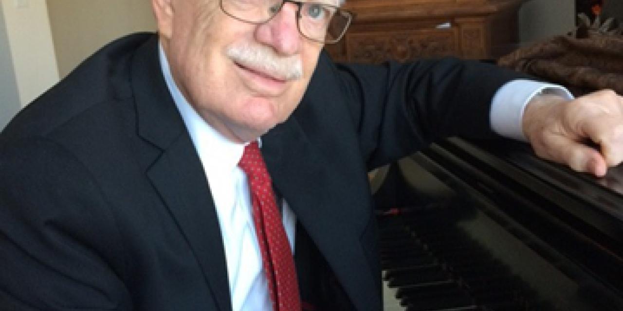 William sitting at a piano.